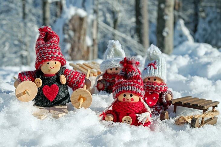 na śniegu drewniane figurki w zimowych ubraniach