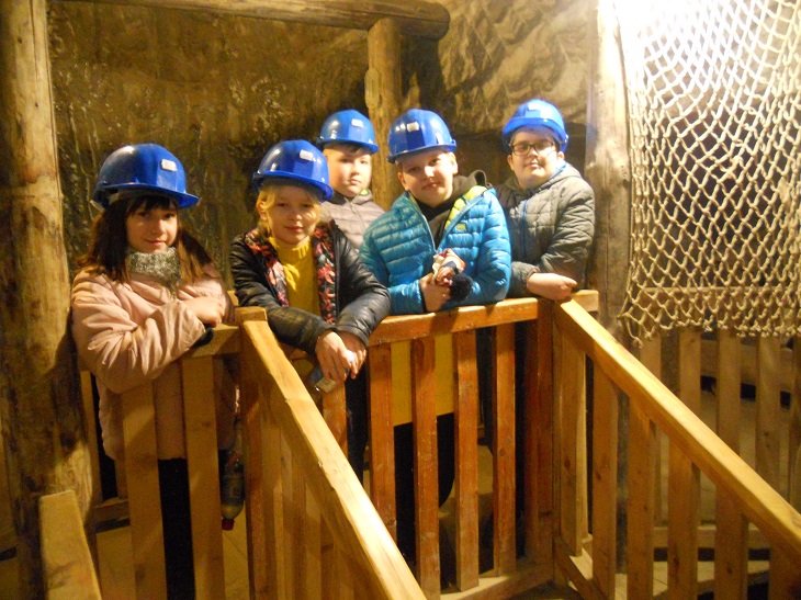 Uczniowie w niebieskich kaskach w kopalni soli w Wieliczce