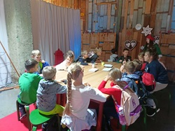 Uczestnicy wycieczki do Fabryki Elfów siedza przy stole