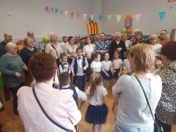 Dzieci w sali tańczą z babciami i dziadkami