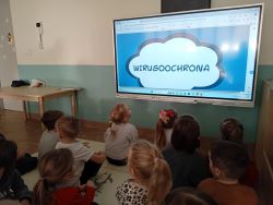 Dzieci oglądają prezentację multimedialną na temat wirusoochrony
