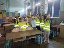 Na zdjęciu uczniowie klas I–III biorą udział w „Teście ciemności” w ramach Ogólnopolskiego Konkursu „Odblaskowa szkoła”. Dzieci ubrane w kamizelki odblaskowe prezentują różnego rodzaju elementy odblaskowe, sprawdzając, jak zwiększają one widoczność po zmroku. To praktyczna i ciekawa lekcja, która uczy najmłodszych, jak dbać o własne bezpieczeństwo na drodze.