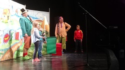 Na scenie aktorzy i dzieci stoją 