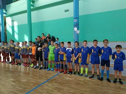 drużyna piłkarzy stoi w sali gimnastycznej