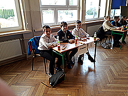 Trzech chłopców siedzi przy stoliku