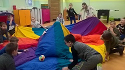 Dzieci trzymają kolorową tkaninę