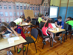 Uczniowie rozwiązują zadania w trakcie konkursu czytelniczego
