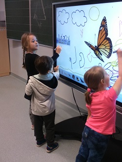 dzieci rysują na tablicy multimedialnej