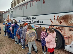 dzieci wchodzą do autobusu, w którym będą zajęcia z czekoladą