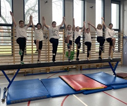 Dziewczynki stoja na równoważni, sala gimnastyczna sp. 18, lekcja w-f