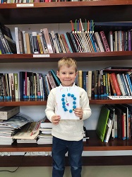 na zdjęciu w jego centrum stoi dziecko trzymające kartkę papieru, tytułową stronę pamiętnika