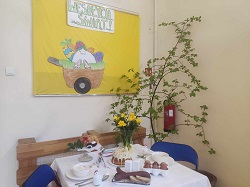 na zdjęciu znajduje się stół z wielkanocną dekoracją , jajka, wędlina , kwiaty, babka i mazurek