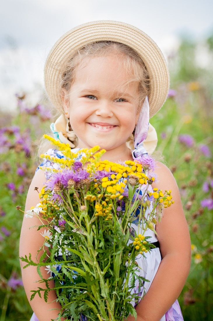 dziewczynka z polnymi kwiatami w dłoniach