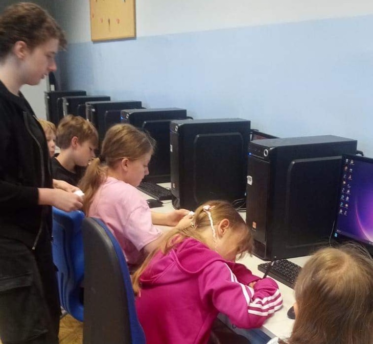 Uczniowie biora udział w wyborach do samorzadu uczniowskiego, na zdjęciu uczennice w sali komputerowej oddają głosy do urny
