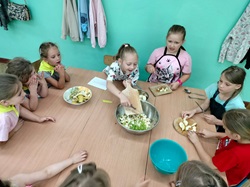 uczniowie przy stole uczą się komponować zdrowe posiłki