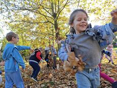 szczęśliwe dzieci rzucające się liściami