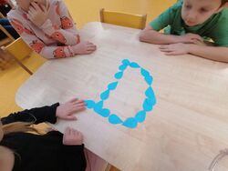 Litera D ułożona z papierowych kropelek