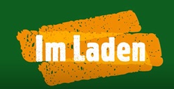 Na obrazie znajduje się napis „Im Laden” (po niemiecku „W sklepie”). Tekst jest w białej, lekko postrzępionej czcionce i umieszczony na tle pomarańczowych, nieregularnych, pociągnięć przypominających farbę lub pędzel. Tło całego obrazu jest w kolorze ciemnej zieleni.