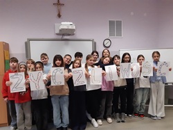 uczniowie stoją przy szafie i trzymają kartki tworzące napisz życzliwość