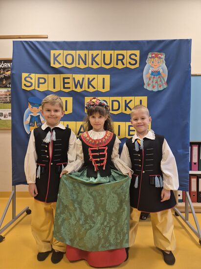 trójka dzieci ubrana w stroje ludowe występująca w konkursie o tematyce Śląska