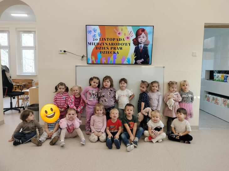 dzieci stojące pod telewizorem, na telewizorze napis: Międzynarodowy Dzień Praw Dziecka