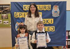 uśmiechnięta  nauczycielka z dwójką dzieci ubranych w stroje ludowe - śląskie