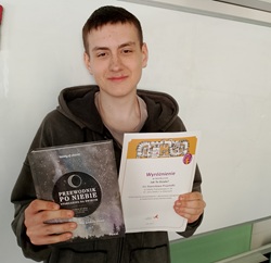Uczeń Stanisław pokazuje dyplom za konkurs fizyczny