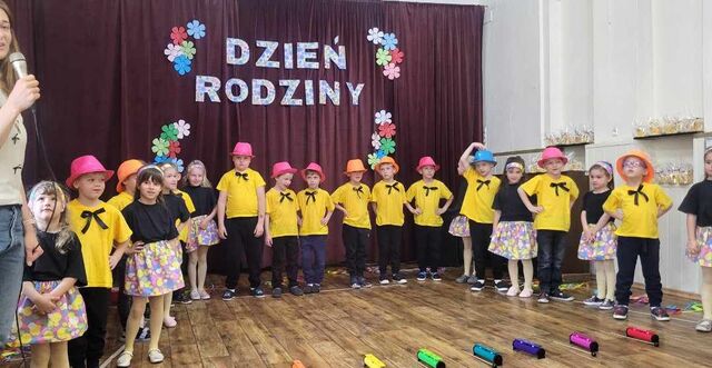 grupa uśmiechniętych dzieci na występie ubrane w stroje
