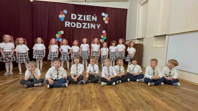grupa uśmiechniętych dzieci na występie ubrane w stroje