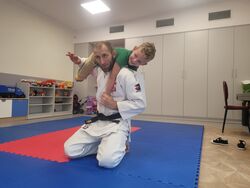 Trener JUDO trzymający dziecko z grupy Iskierek