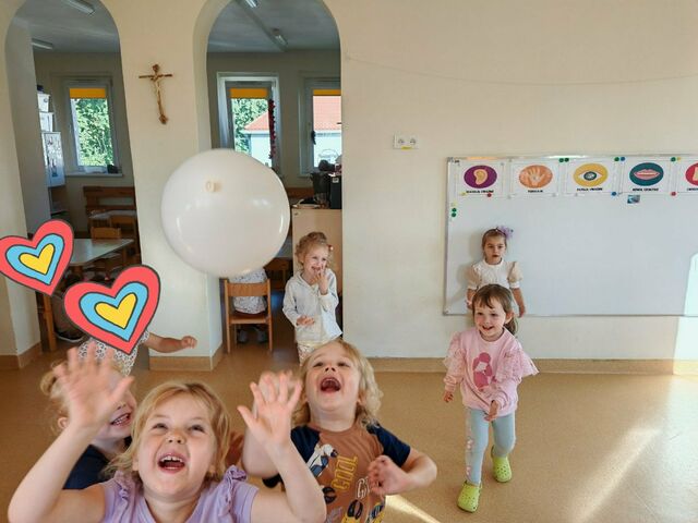 uśmiechnięte dzieci bawią się balonikiem