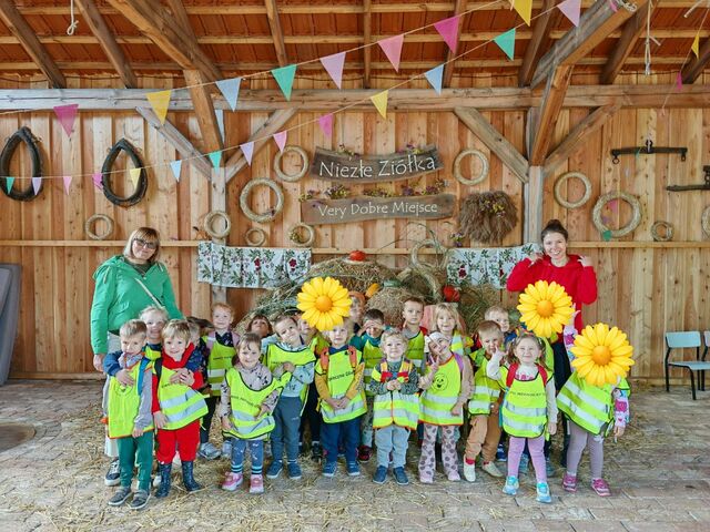 grupa uśmiechniętych  dzieci na wycieczce wraz z opiekunami