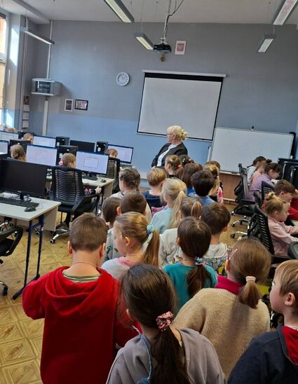 dzieci stojące tyłem w klasie szkolnej