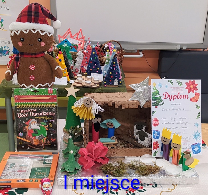 Na zdjęciu widoczna jest praca konkursowa, która zdobyła I miejsce w szkolnym konkursie na najpiękniejszą ozdobę bożonarodzeniową. Przedstawia starannie wykonaną szopkę bożonarodzeniową z licznymi elementami dekoracyjnymi. Kompozycja wyróżnia się pomysłowością, estetyką oraz dbałością o detale
