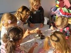 dzieci tworzące rysunki przy stoliku