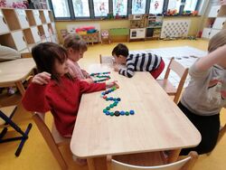 Grupa Kropelek układająca literę W z nakrętek