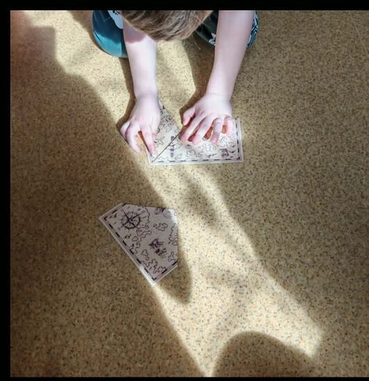 chłopiec leżący na podłodze i u układający fragmenty obrazka