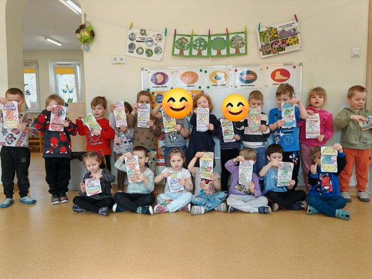 grupa dzieci pod ścianą uśmiechnięta