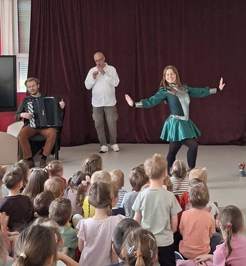 na scenie tańcząca kobieta, w tle mężczyzna grający na flecie oraz drugi na akordeonie