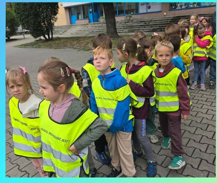 dzieci idące przez pasy drogowe w odblaskowych kamizelkach